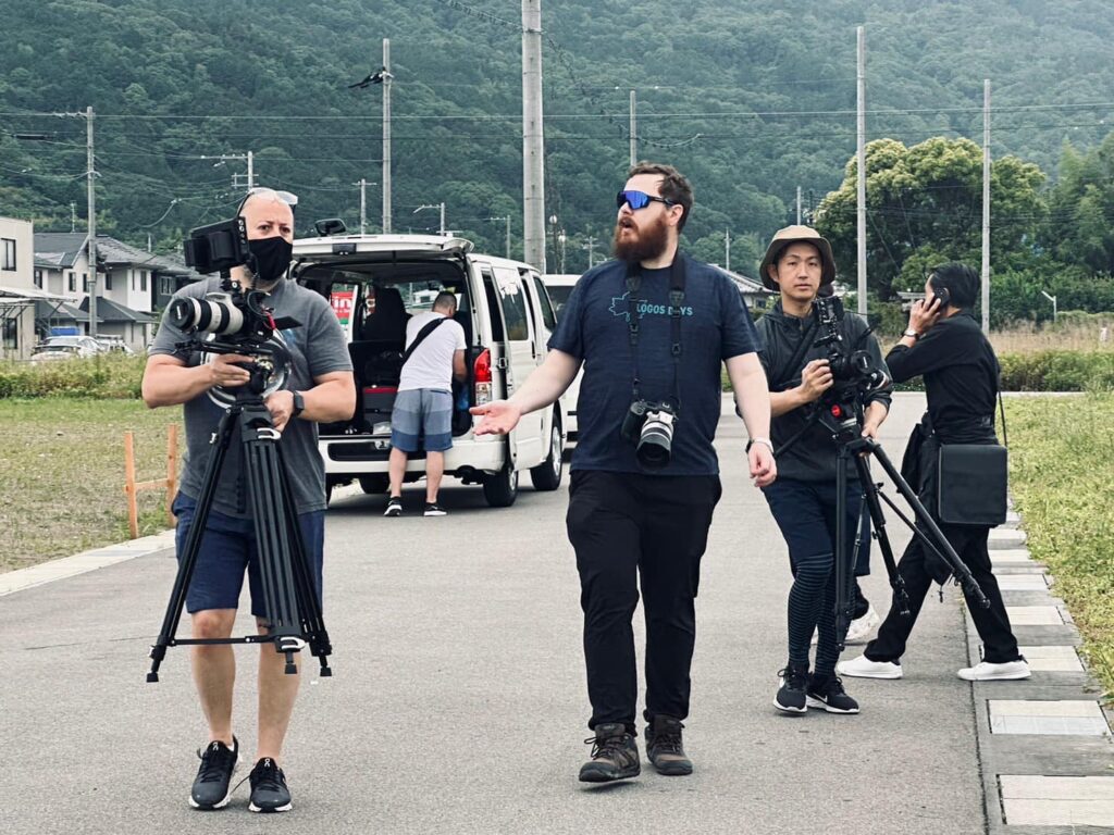 Film crew moving equipment on a Japanese forest road