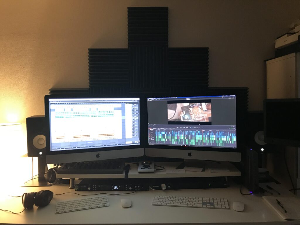 In editing room two computer monitors are set up with film editing software and hard drive.
