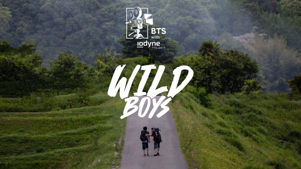 Film poster of Wild Boys, two teenagers walk on a path into the forest. Title reads BTS with iodyne Pro Data