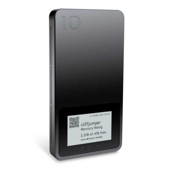 A small, black, phone-sized Pro Mini in three-quarter view, standing vertically. An e-paper Digital Label shows an example state with a QR code, device name, project name, contact phone number, usage described as 