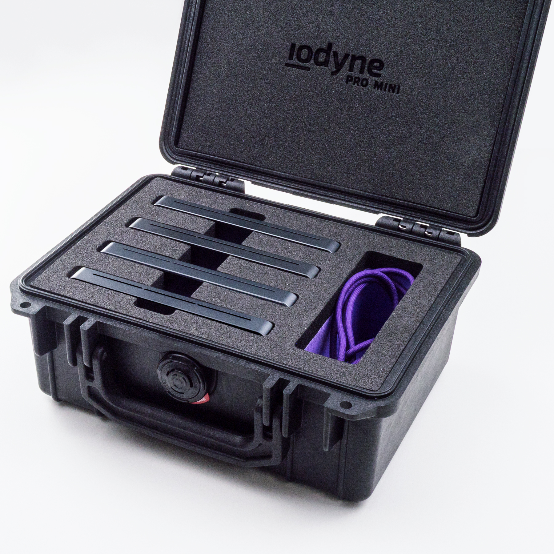 A black, toolbox-sized Pelican case is open to reveal custom closed-cell foam with four horizontal slots populated with Pro Mini devices at left, and a wider vertical slot containing Thunderbolt cables and other Pro Mini accessories