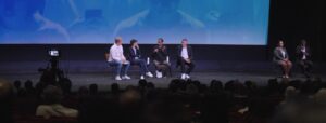 four panelists and ASL translators on a stage