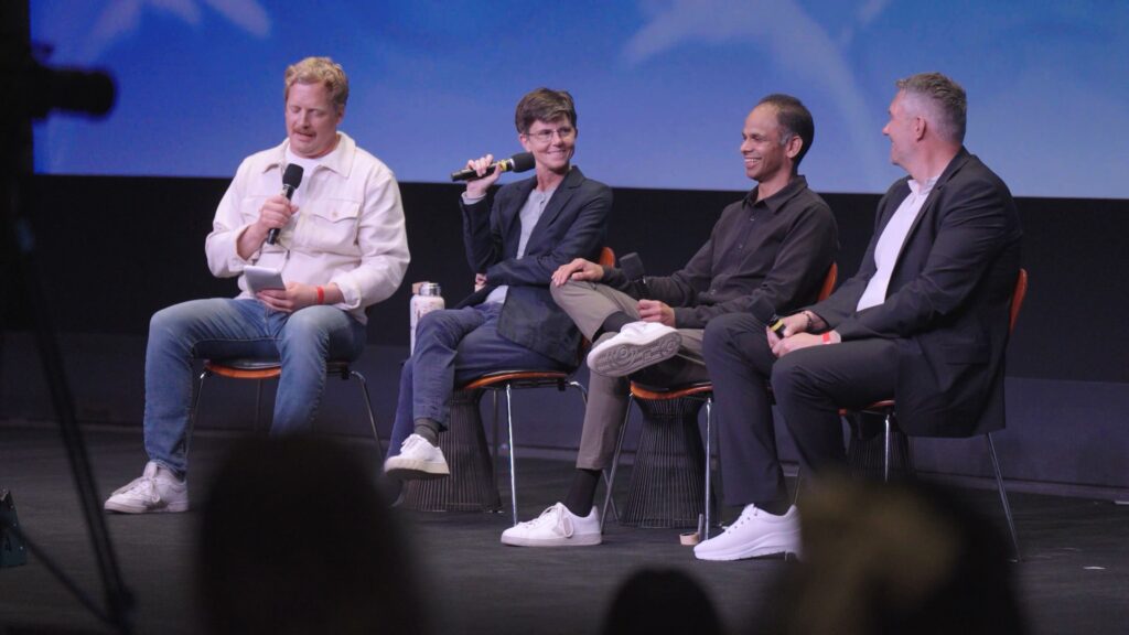 Panelists on a stage sitting on chairs