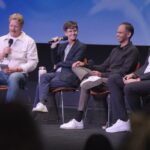 Panelists on a stage sitting on chairs