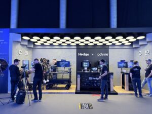 DIT carts, cameras, and monitors set up at a tradeshow for video production, and exhibitors meeting attendees